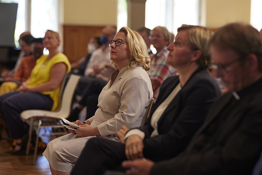 Ein Publikum sitzt aufmerksam und hört der Diskussion zu.