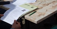 Dokumente und Schreibmaterialien auf einem Holztisch, vorbereitet für ein Seminar.