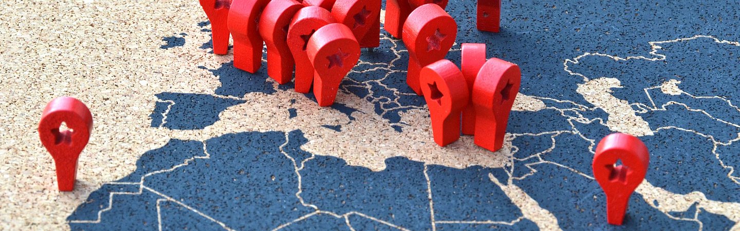 Eine Karte von Europa und angrenzenden Regionen mit zahlreichen roten Markierungen, die auf bestimmte Orte hinweisen. Die Karte ist in blauen und beigen Farben gehalten, und die Markierungen symbolisieren wichtige Standorte oder Aktivitäten