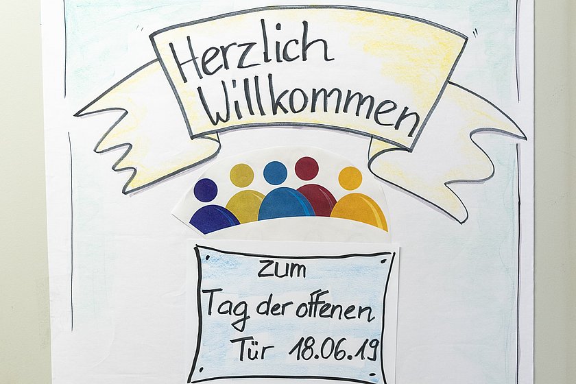 Herzlich-Willkommen-Plakat zum Tag der offenen Tür der AGdD.